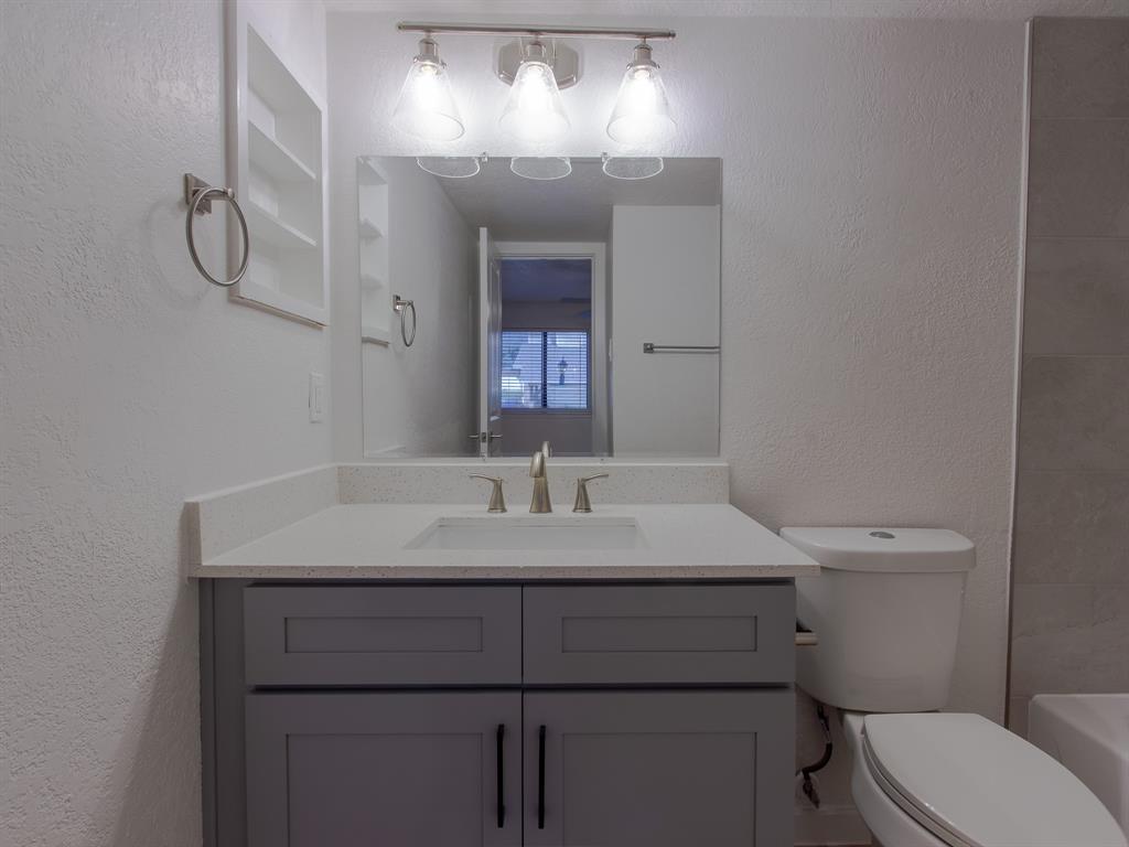 2240 Tarpley Road, Unit 62 Carrollton, TX 75006 - Photo 12 of 20 a bathroom with a sink a toilet and a mirror
