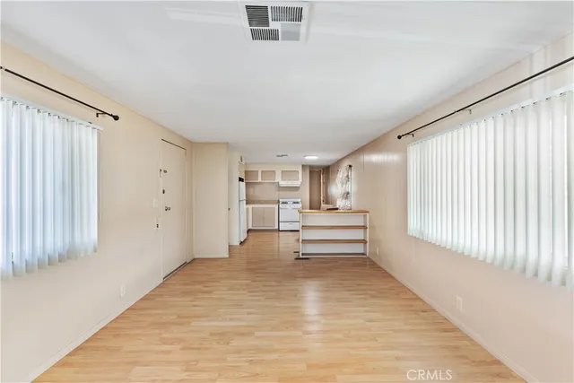 a view of empty room with wooden floor and fan