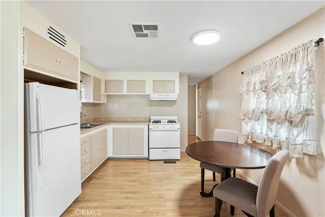 a kitchen with stainless steel appliances refrigerator and dining table