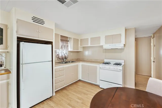 a kitchen with stainless steel appliances a refrigerator sink and cabinets