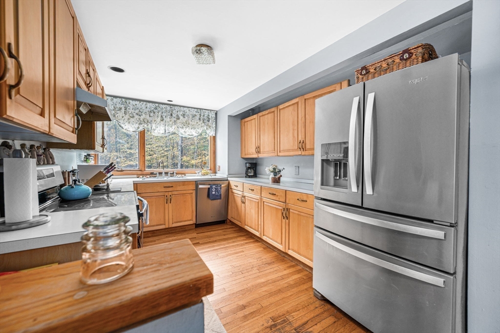 16 Wheeler Road Princeton, MA 01541 - Photo 6 of 40 a kitchen with stainless steel appliances kitchen island granite countertop a refrigerator a sink dishwasher a stove and white cabinets with wooden floor