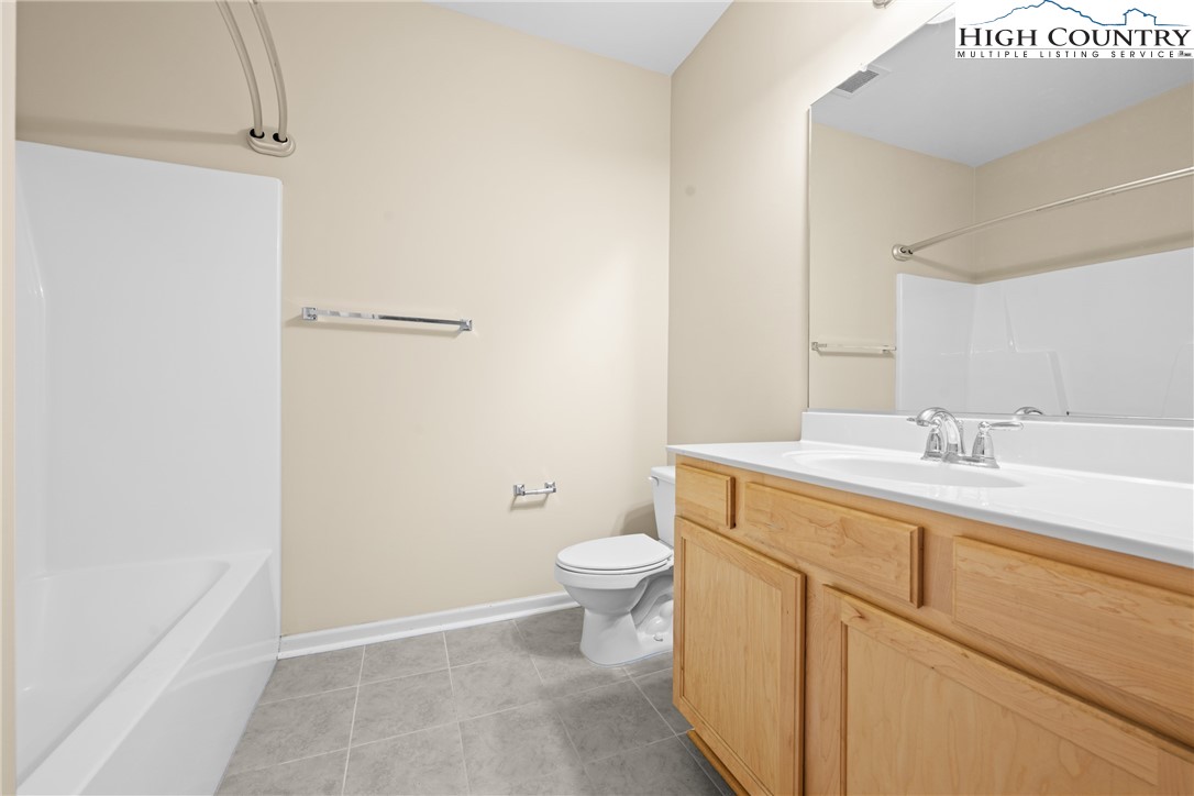 247 Eli Hartley Drive, Unit 111 Boone, NC 28607 - Photo 23 of 28 a bathroom with a sink a toilet and a mirror