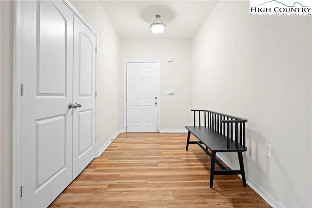 a view of a hallway with wooden floor and staircase