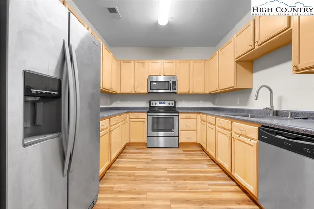 a kitchen with granite countertop a refrigerator and a sink