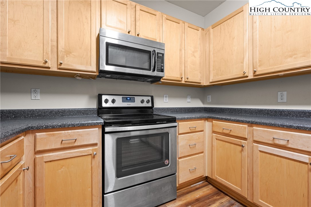 247 Eli Hartley Drive, Unit 111 Boone, NC 28607 - Photo 8 of 28 a kitchen with granite countertop white cabinets stainless steel appliances and a sink