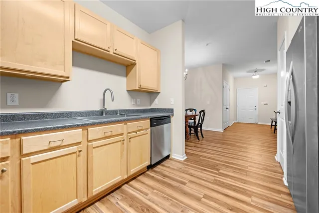 a kitchen with stainless steel appliances granite countertop a sink a stove and refrigerator