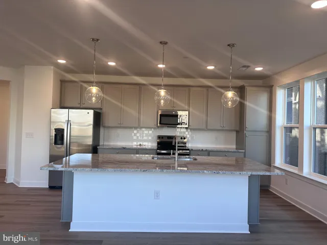 a large kitchen with stainless steel appliances a large counter top