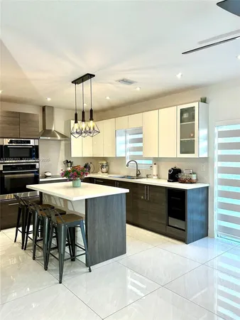 a large kitchen with a large counter top and stainless steel appliances