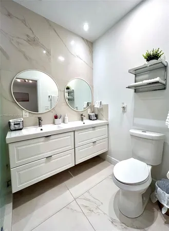a bathroom with a toilet a sink and mirror