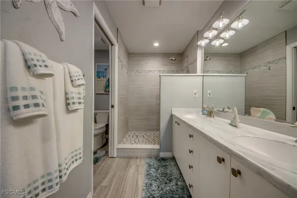 a bathroom with a double vanity sink mirror and shower