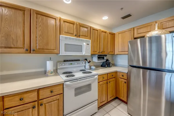 a kitchen with a refrigerator a stove a sink and cabinets