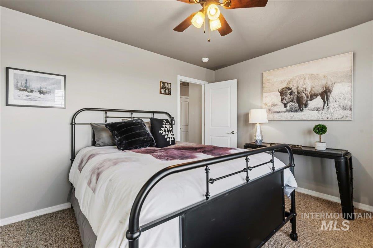 11660 Timber Butte Road Sweet, ID 83670 - Photo 22 of 49 Textured carpeting, warm neutral wall paint, and a wood-finish ceiling fan with integrated lighting
