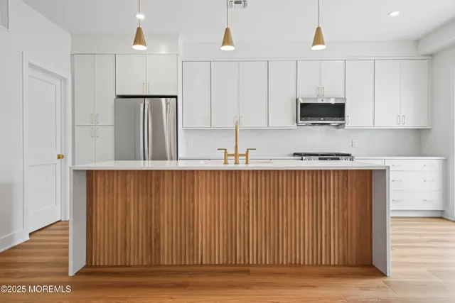 a kitchen with stainless steel appliances granite countertop a refrigerator sink and microwave