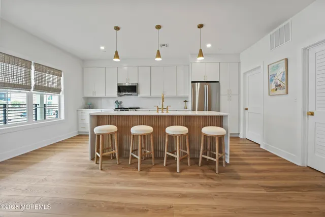 a large kitchen with cabinets table and chairs