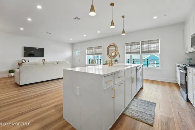 a large white kitchen with a large window a sink and a large window