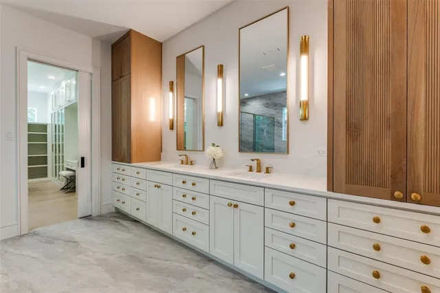 a bathroom with double vanity sink a two mirror a window and vanity