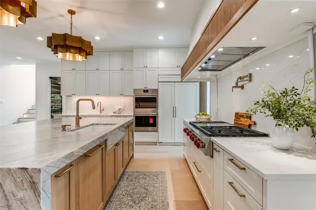 a kitchen with stainless steel appliances granite countertop a sink and a stove
