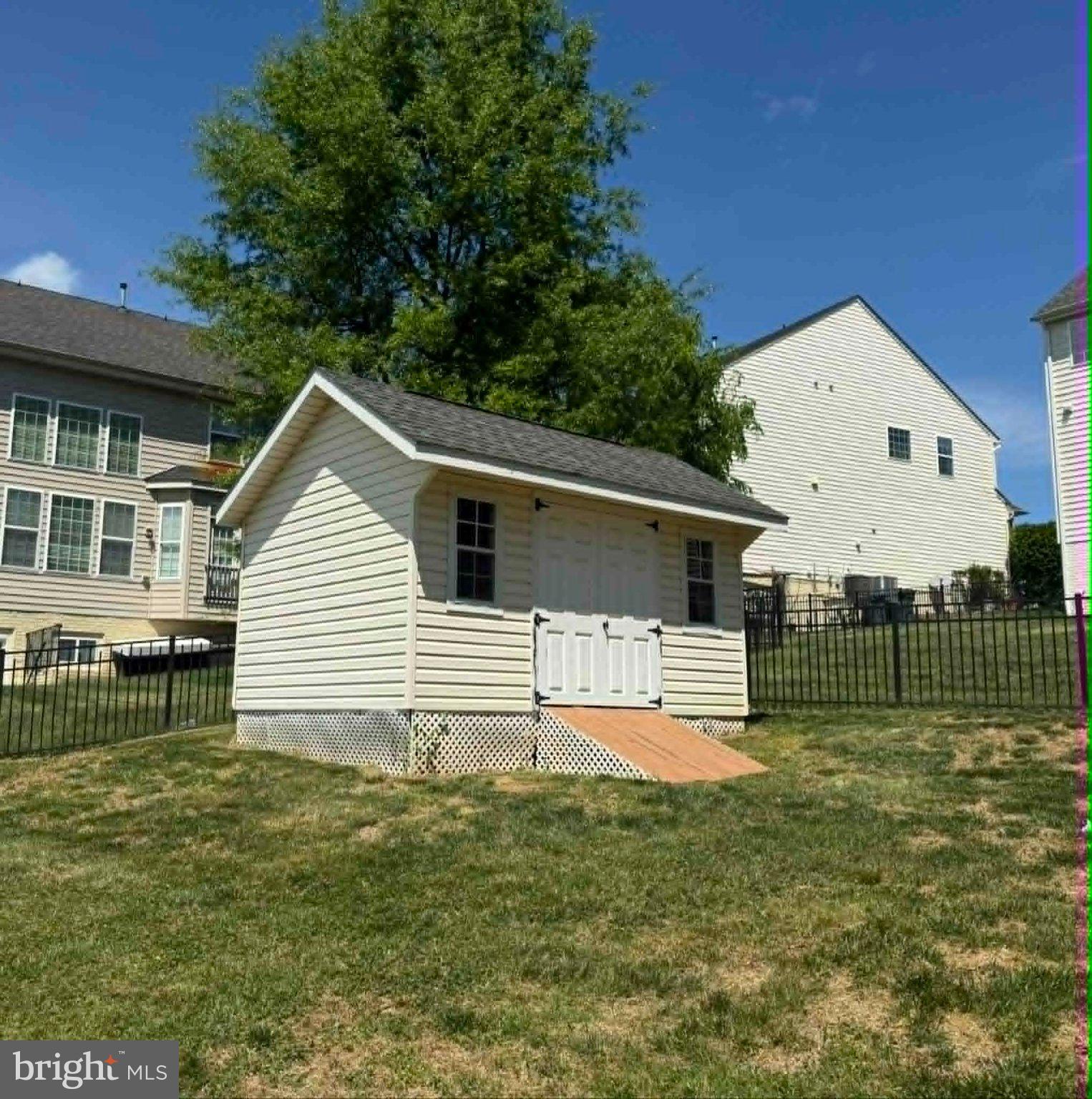 16380 Rusty Rudder Drive Woodbridge, VA 22191 - Photo 2 of 3 Charming backyard shed with greenery.