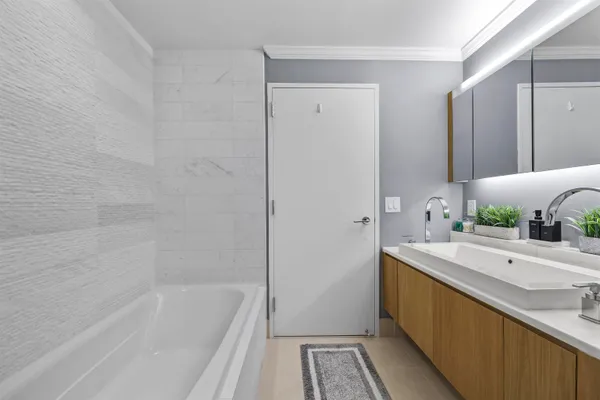 a bathroom with a tub sink and mirror
