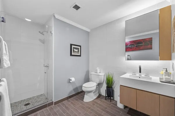 a bathroom with a granite countertop sink a toilet and a mirror
