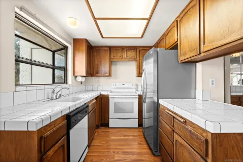 a kitchen with granite countertop a sink stainless steel appliances and cabinets
