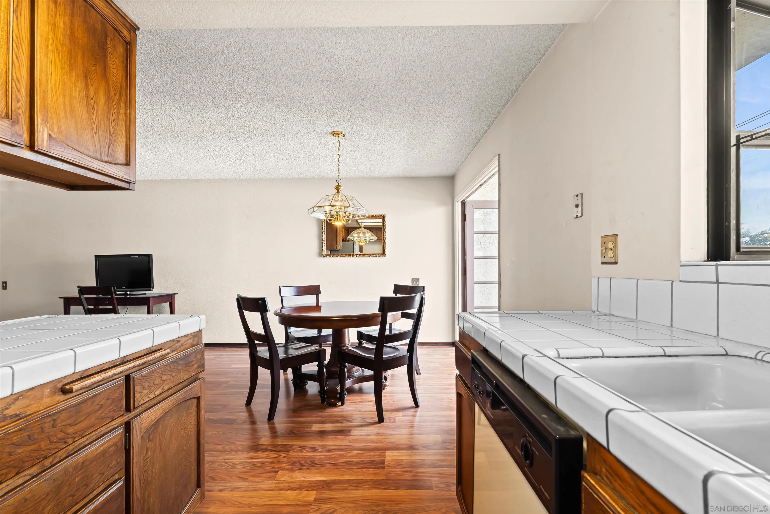 1263 Robinson Avenue, Unit 13 San Diego, CA 92103 - Photo 12 of 40 a kitchen with a stove a sink a dining table and chairs