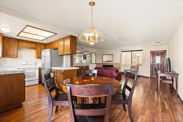 a dining room with furniture a chandelier and wooden floor