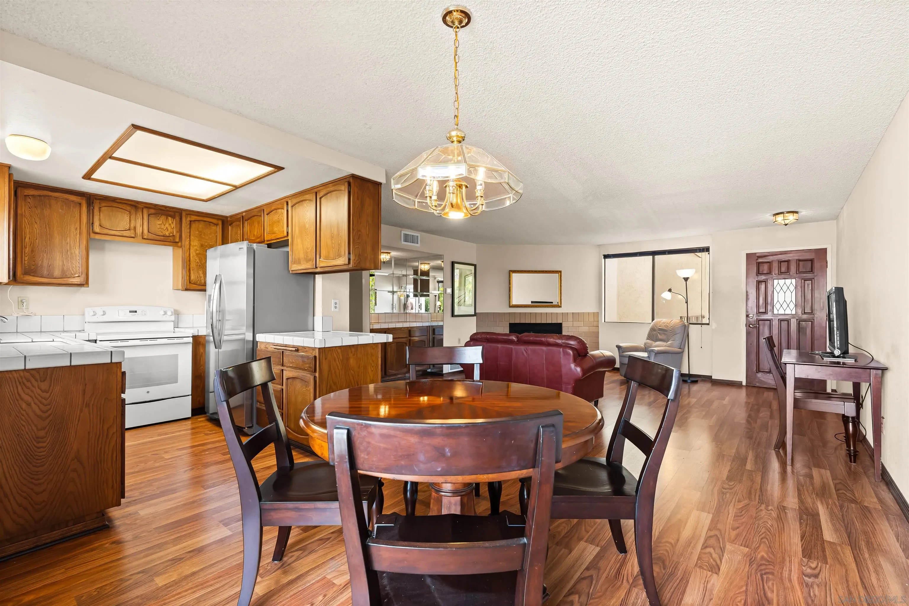 1263 Robinson Avenue, Unit 13 San Diego, CA 92103 - Photo 7 of 40 a dining room with furniture a chandelier and wooden floor