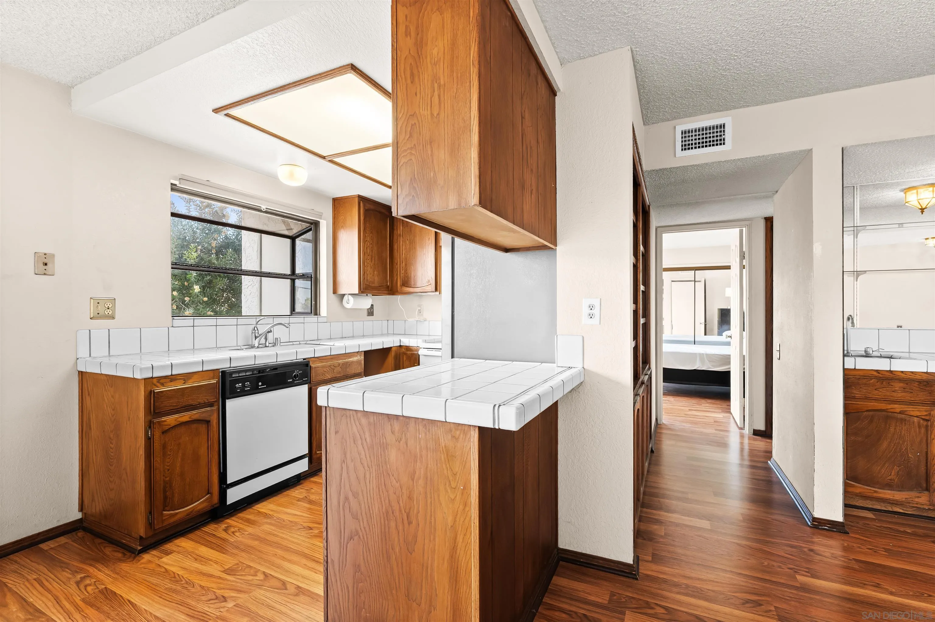 1263 Robinson Avenue, Unit 13 San Diego, CA 92103 - Photo 10 of 40 a kitchen with stainless steel appliances granite countertop a sink and wooden cabinets with wooden floors