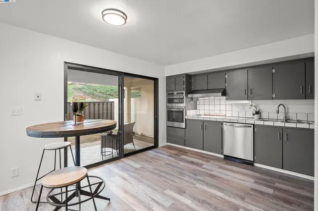 a kitchen with granite countertop a stove a sink and a refrigerator