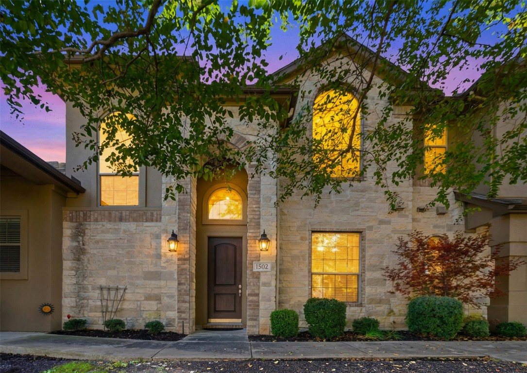 Exterior entry at dusk with stone siding