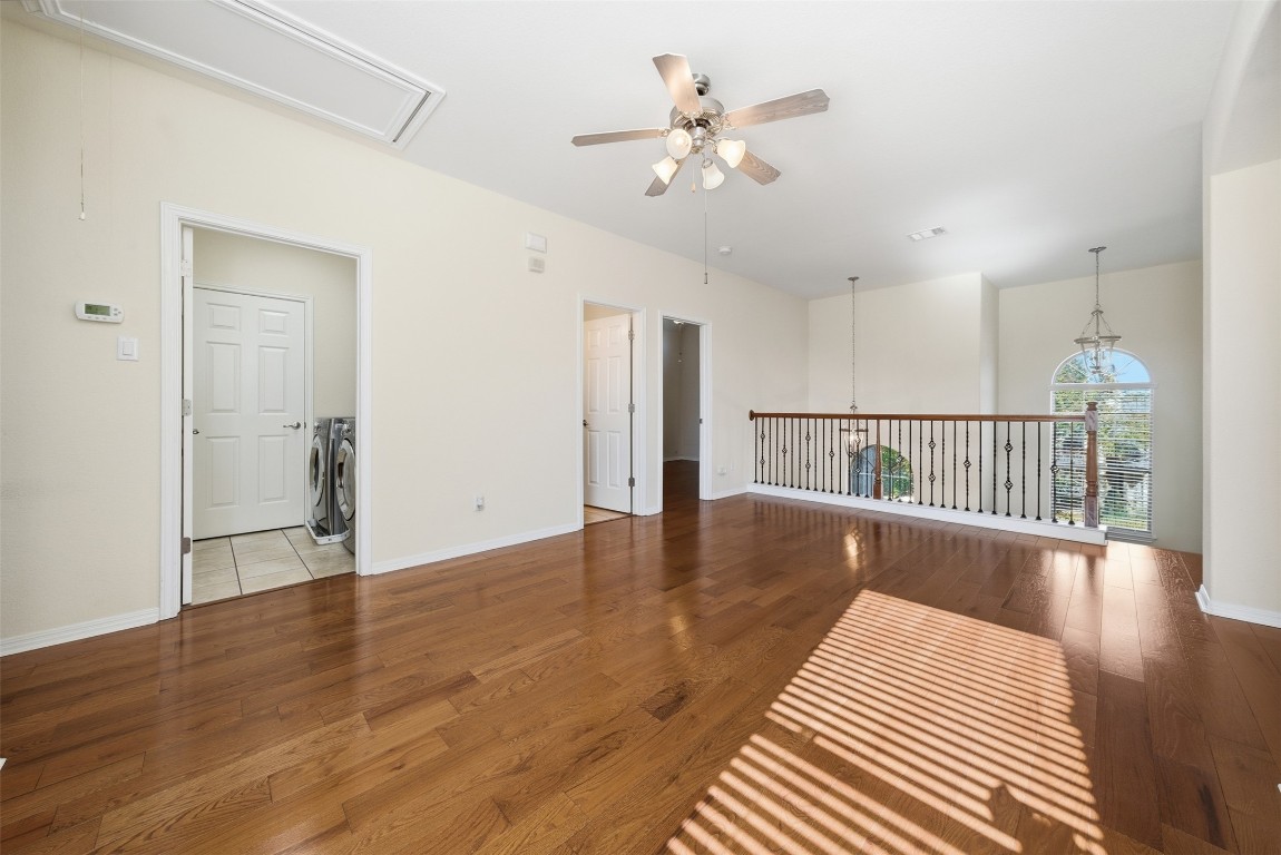 14100 Avery Ranch Boulevard, Unit 1502 Austin, TX 78717 - Photo 16 of 39 Empty room featuring ceiling fan, attic access, wood-type flooring, and independent washer and dryer
