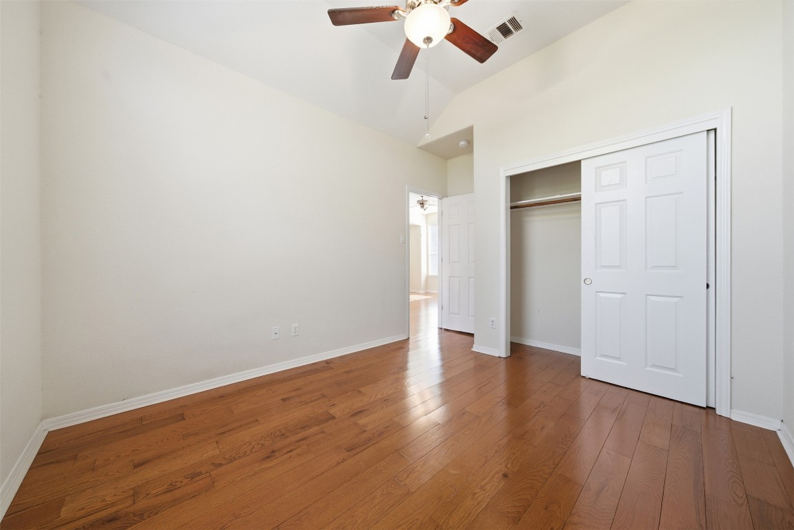 14100 Avery Ranch Boulevard, Unit 1502 Austin, TX 78717 - Photo 24 of 39 Unfurnished bedroom with vaulted ceiling, hardwood / wood-style floors, a closet, and ceiling fan