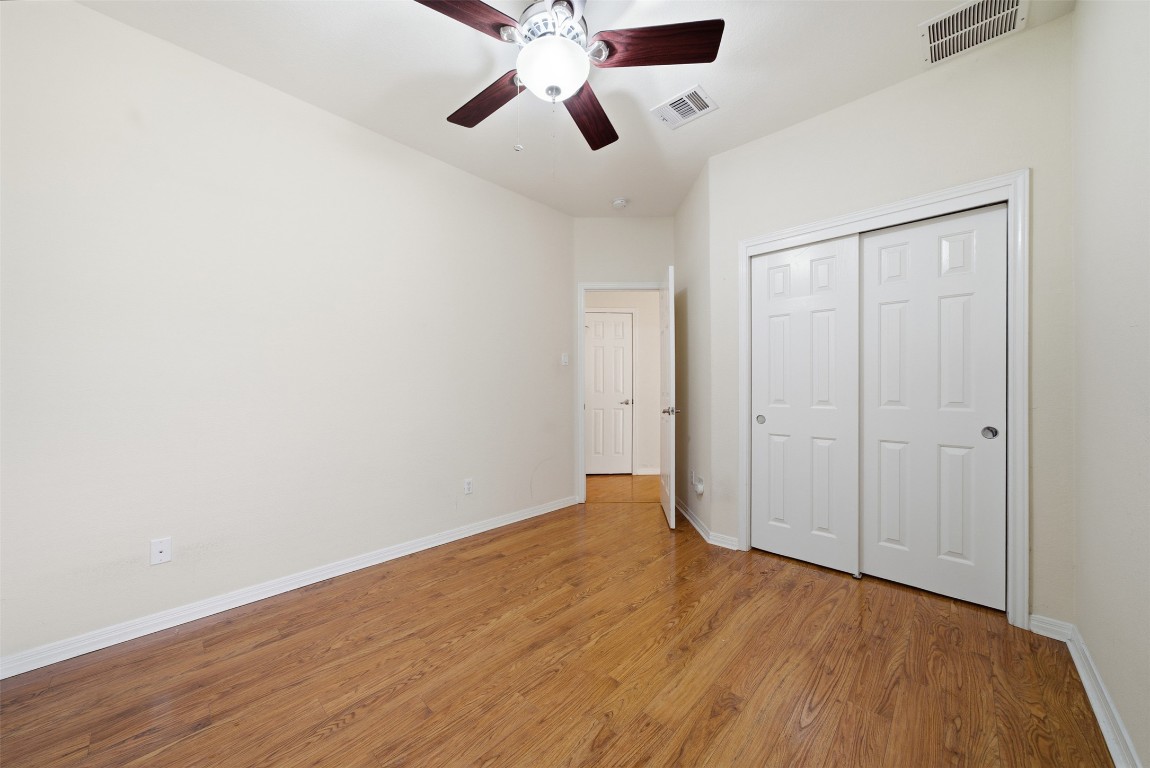 14100 Avery Ranch Boulevard, Unit 1502 Austin, TX 78717 - Photo 26 of 39 an empty room with wooden floor ceiling fan and windows