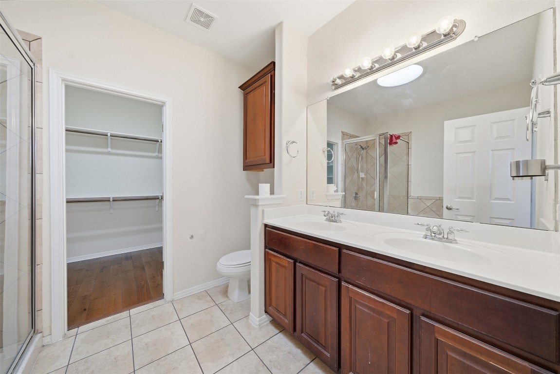 14100 Avery Ranch Boulevard, Unit 1502 Austin, TX 78717 - Photo 27 of 39 a spacious bathroom with a double vanity sink mirror and toilet
