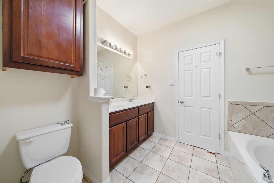 14100 Avery Ranch Boulevard, Unit 1502 Austin, TX 78717 - Photo 28 of 39 a bathroom with a granite countertop toilet sink and mirror