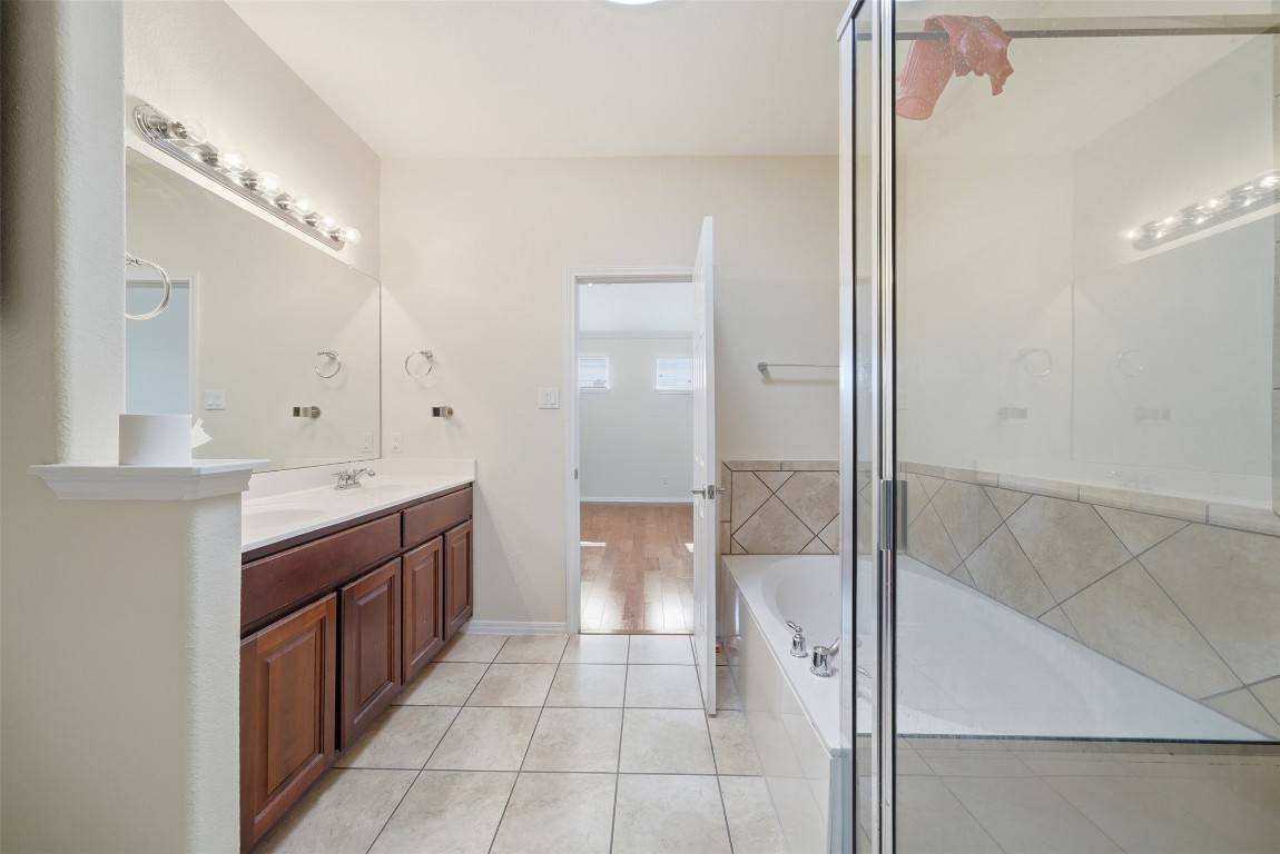 14100 Avery Ranch Boulevard, Unit 1502 Austin, TX 78717 - Photo 29 of 39 a bathroom with a glass door shower a sink and a mirror
