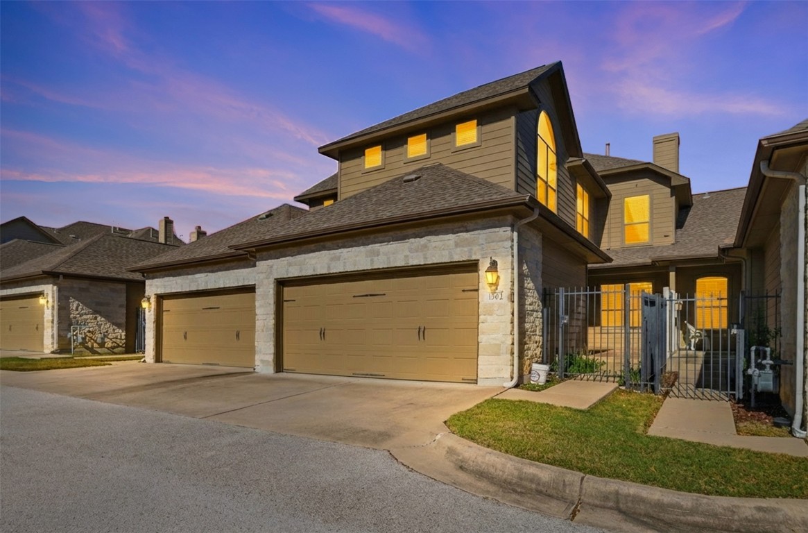 14100 Avery Ranch Boulevard, Unit 1502 Austin, TX 78717 - Photo 39 of 39 View of front of property with stone siding, concrete driveway, a gate, and a shingled roof
