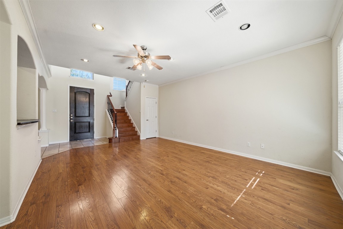 14100 Avery Ranch Boulevard, Unit 1502 Austin, TX 78717 - Photo 5 of 39 a view of an empty room with wooden floor and a ceiling fan