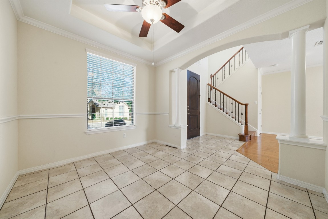 14100 Avery Ranch Boulevard, Unit 1502 Austin, TX 78717 - Photo 8 of 39 Spare room featuring light tile patterned floors, crown molding, a raised ceiling, stairway, and arched walkways