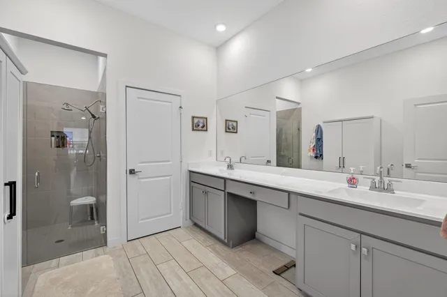 a bathroom with a sink a toilet a mirror and shower