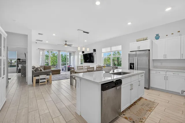 a kitchen with center island wooden floor and a view of living room