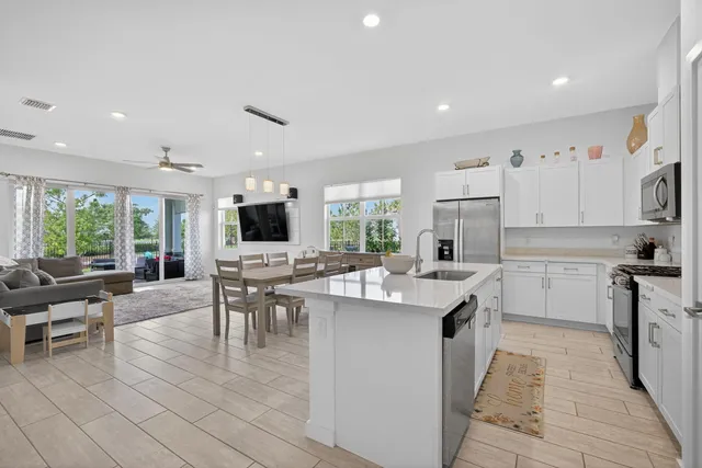 a kitchen with white cabinets and stainless steel appliances
