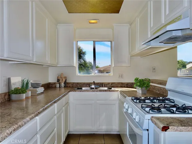 a kitchen with a stove a sink and a window