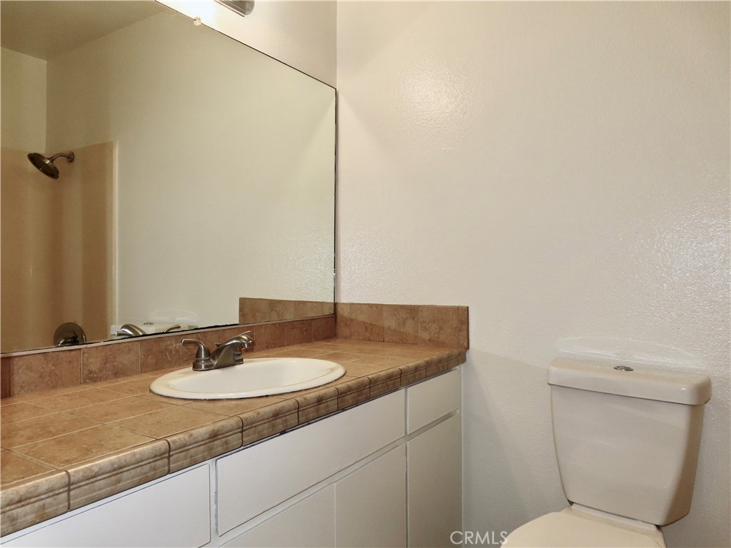 6149 La Sierra Avenue Riverside, CA 92505 - Photo 17 of 37 a bathroom with a granite countertop sink and a mirror