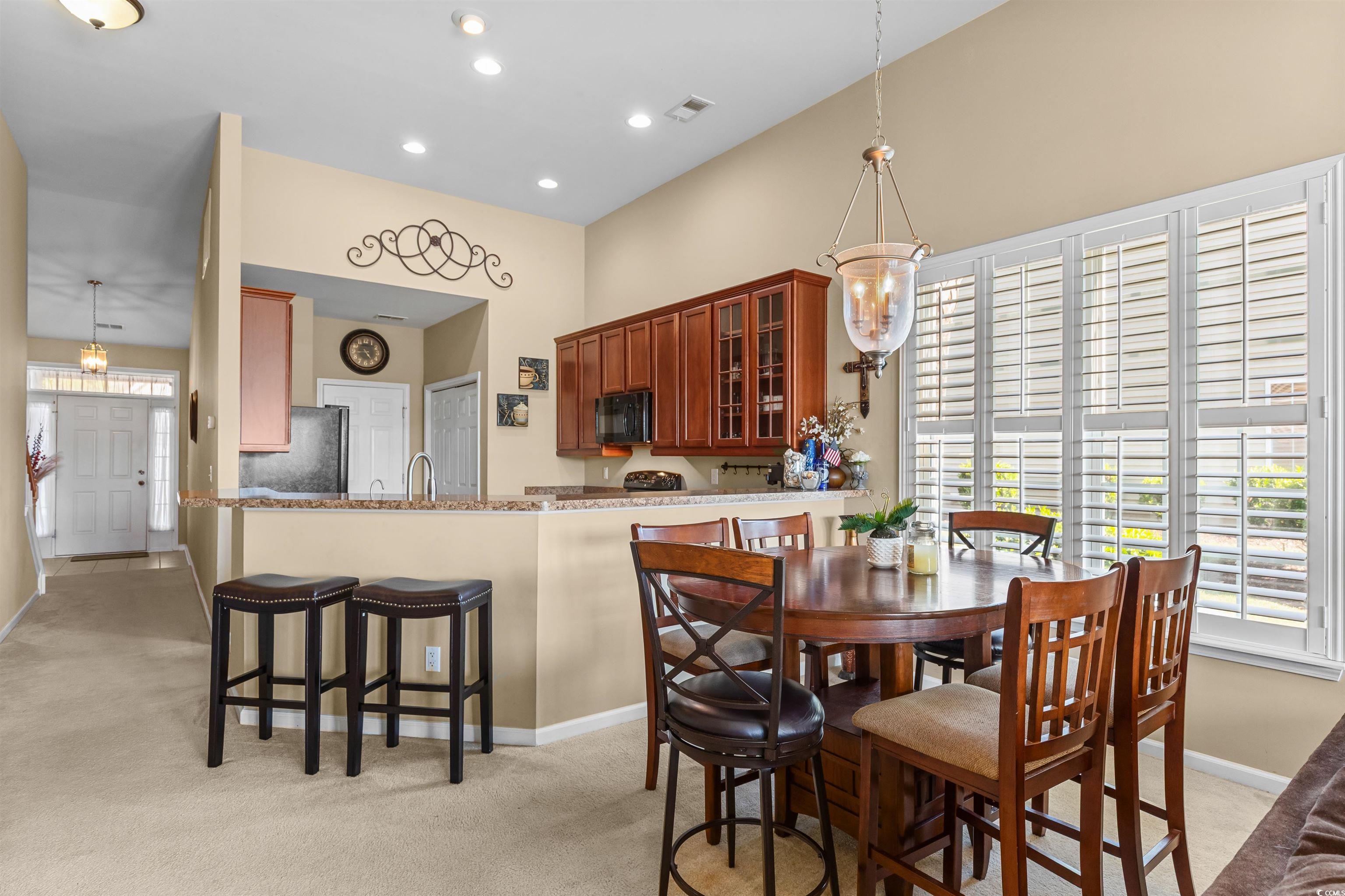 3233 Volterra Way, Unit 3233 Myrtle Beach, SC 29579 - Photo 16 of 40 Dining area featuring healthy amount of natural light, light colored carpet, recessed lighting, and a chandelier