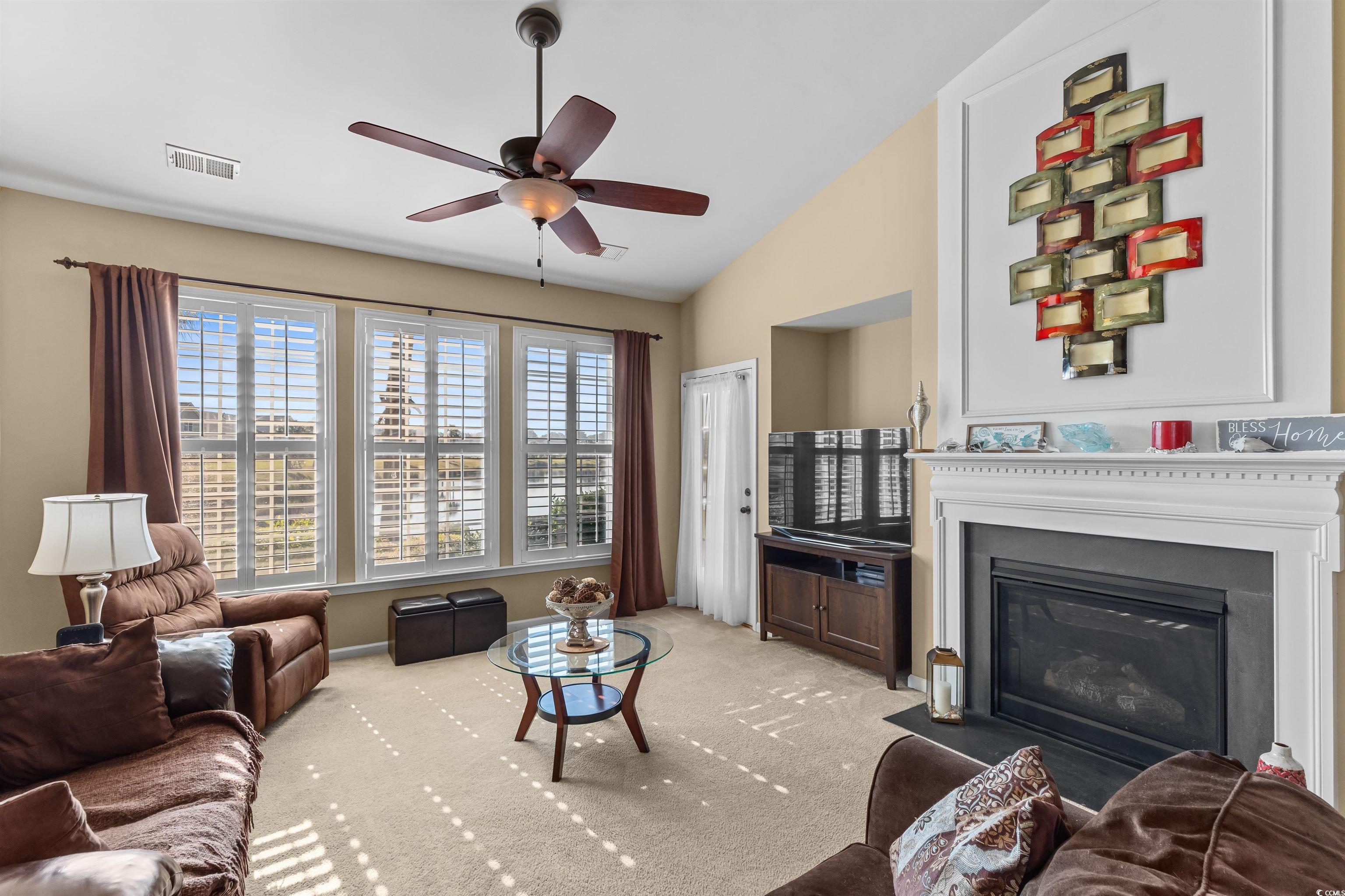 3233 Volterra Way, Unit 3233 Myrtle Beach, SC 29579 - Photo 18 of 40 Carpeted living area with a fireplace with flush hearth, ceiling fan, and vaulted ceiling