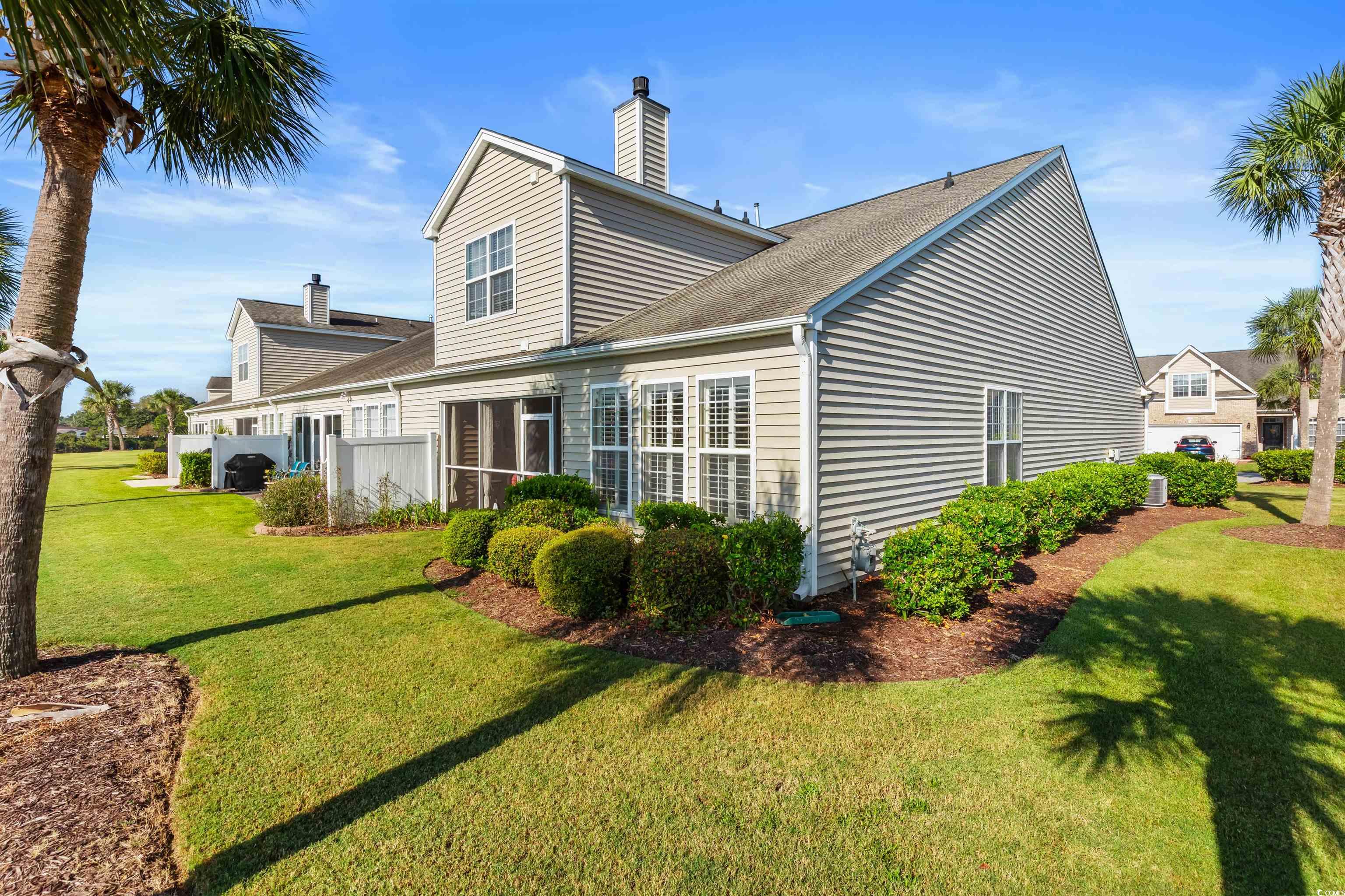 3233 Volterra Way, Unit 3233 Myrtle Beach, SC 29579 - Photo 2 of 40 Rear view of property with a shingled roof, a chimney, and a yard