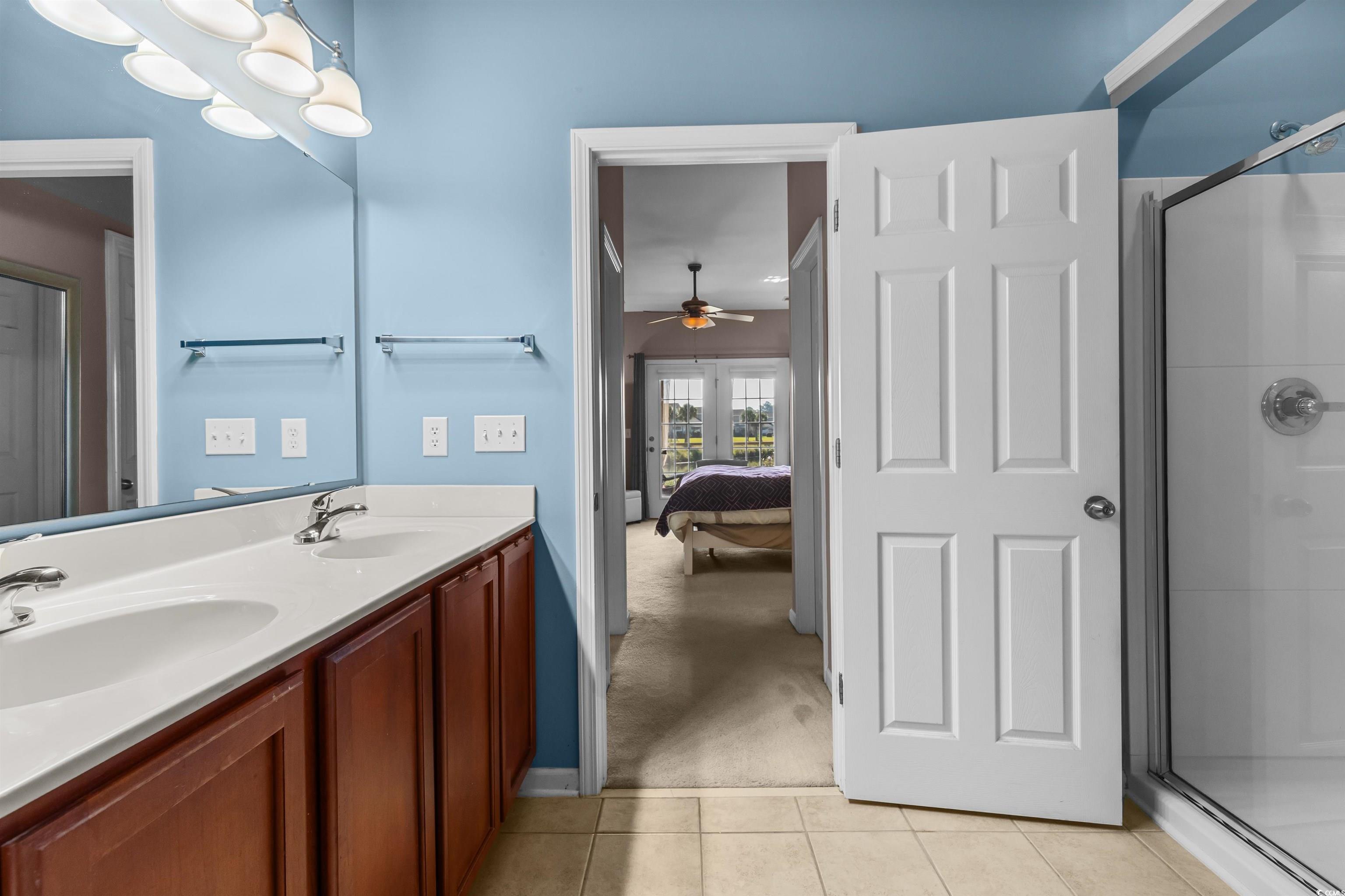 3233 Volterra Way, Unit 3233 Myrtle Beach, SC 29579 - Photo 23 of 40 Full bath with a stall shower, double vanity, light tile patterned flooring, and connected bathroom