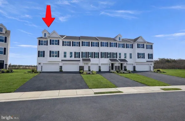 a view of a big house with a yard and plants